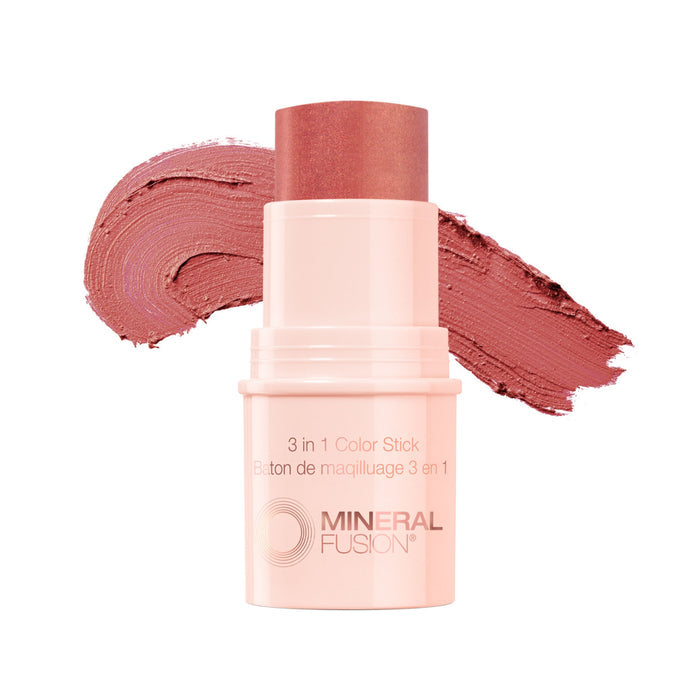 A Mineral Fusion 3-in-1 Color Stick is shown uncapped, displaying its rosy pink makeup stick, with a matching swatch of the cheek tint smeared in the background.
