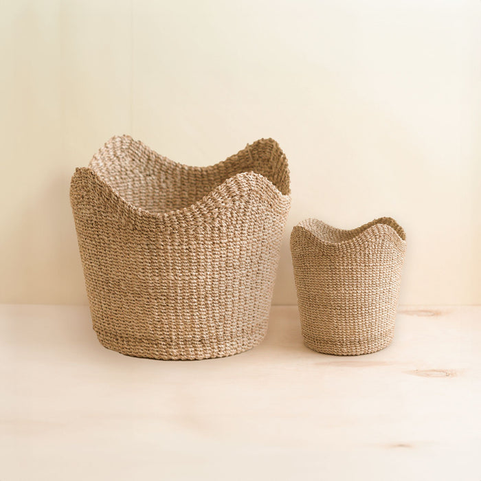 The LIKHA Abaca Small Scallop Basket, ethically crafted from Manila hemp, features a natural color and subtle texture, adding warmth to any space. This versatile basket is perfect for organizing or displaying items in your home.