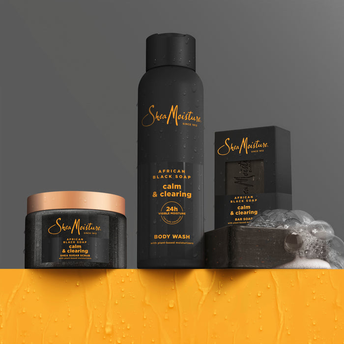 SheaMoisture’s African Black Soap Bar Soap with Shea Butter is showcased on a wet surface with water droplets, set against a gray and orange background.