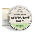 A round metal tin of Lovett Sundries Aftershave Balm features a Creamy & Soothing and Evergreen label with the lid slightly ajar, exposing the creamy balm ideal for soothing skin and preventing razor burn.