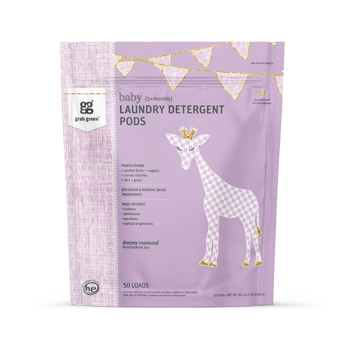 A pastel purple bag of grab green Baby Laundry Detergent Pods (5+ Months) features a giraffe and gold bunting, highlights the “dreamy rosewood” scent, is vegan, and suitable for babies 5+ months.