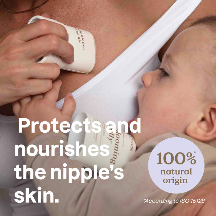 A close-up of a baby breastfeeding while an adult applies ATTITUDE blooming belly Nursing Balm labeled “100% natural origin” to their nipple. Text reads, Protects and nourishes the nipple’s skin.