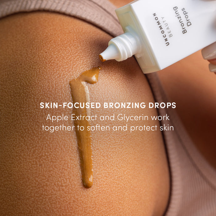 A close-up shows Uncommon Beauty Bronzing Drops applied to a shoulder, with apple extract and glycerin to soften and protect skin for a sunkissed, post-vacation glow.