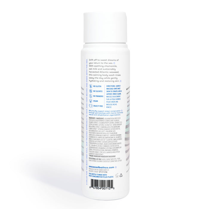 Back view of a Calm Body Wash spray bottle by The Seaweed Bath Co, showcasing product info and instructions. Benefits include soothing and moisturizing with oat milk. A barcode is visible at the bottom.