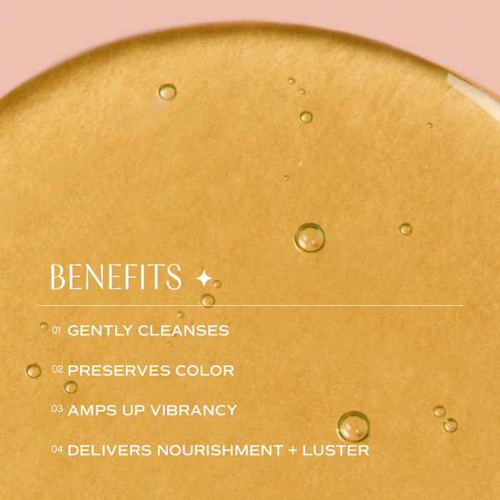 Close-up of a golden liquid with small bubbles. Overlaid text lists benefits: "01 Gently Cleanses, 02 Preserves Color, 03 Amps Up Vibrancy, 04 Delivers Nourishment + Luster" against a pink background.