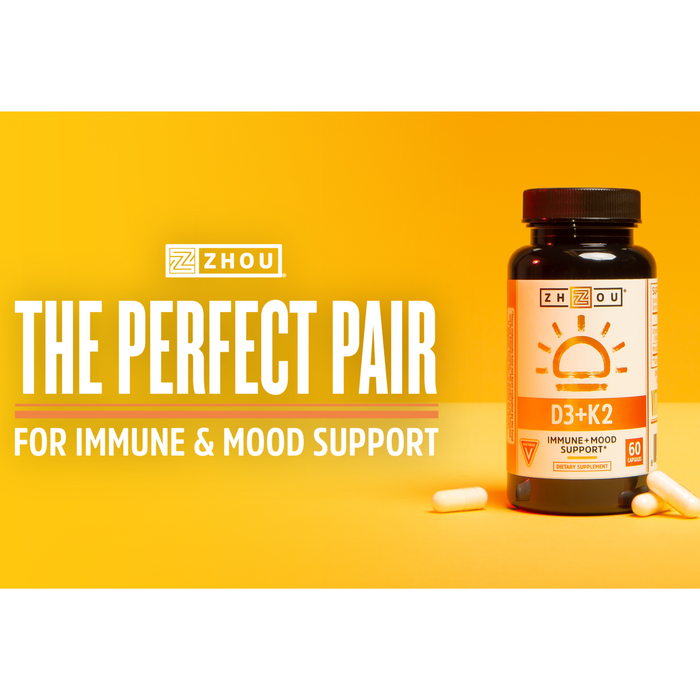 A bottle of Zhou D3+K2 vitamins on a yellow background with two capsules beside it. Text reads "The Perfect Pair for Immune &amp; Mood Support.
