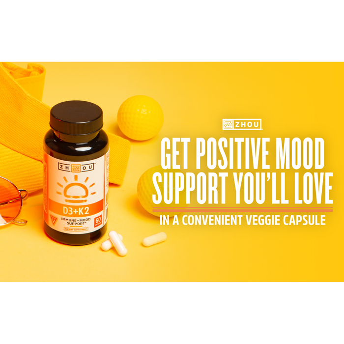 A bottle of Zhou D3+K2 supplements is displayed on a yellow background with a towel, golf ball, and capsules. Text reads: "Get positive mood support you'll love in a convenient veggie capsule.