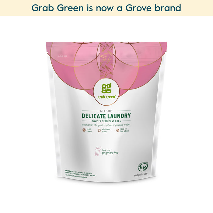 A bag of grab green Delicate Laundry Detergent Pods (Coming Soon!) sits centered on a white background with text above stating, grab green is now a Grove brand. The pods are labeled fragrance free and offer gentle, effective cleaning.