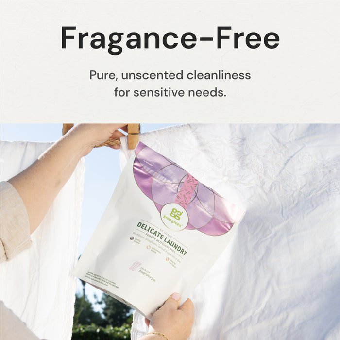 A person hangs a package of fragrance-free, delicate laundry detergent on a white clothesline against a sunny background. The package emphasizes purity and unscented cleanliness for sensitive needs.