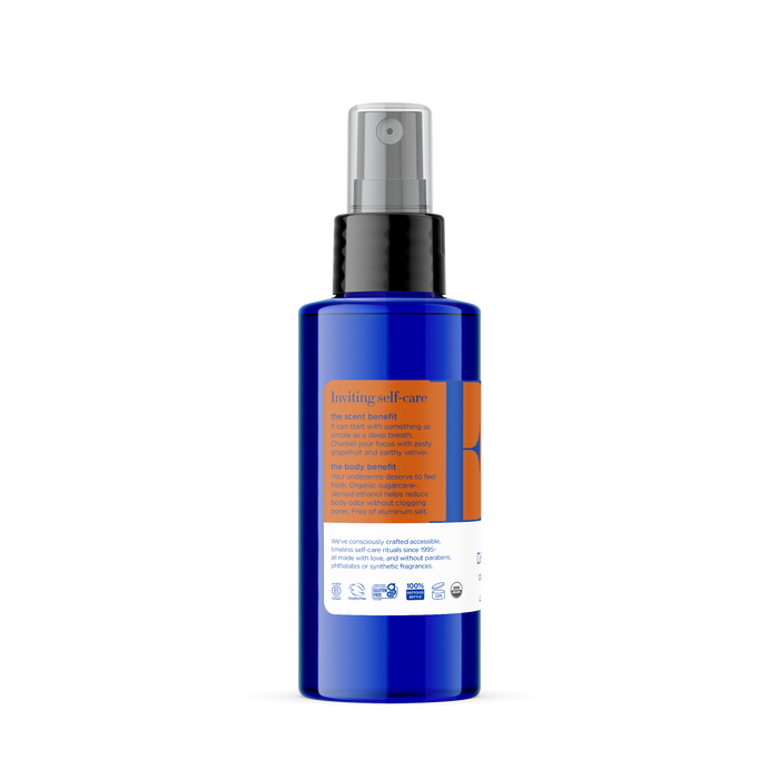 This blue Deodorant Spray from EO Products features a black pump and orange label with white text, highlighting an infusion of organic sugarcane and French lavender. The label also includes product information and certification logos at the bottom.