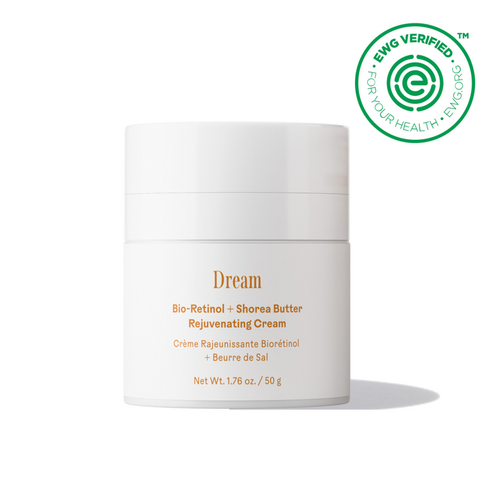 A white jar of Three Ships Dream Bio-Retinol + Shorea Butter Rejuvenating Cream, featuring gold and orange text, sits below the EWG Verified logo on a white background. The vegan squalane cream casts a subtle shadow beneath it.