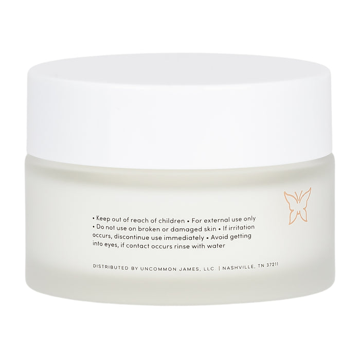 A frosted glass jar with a white lid holds Enhanced Daily Water Cream by Uncommon Beauty. The label includes instructions, safety info, a butterfly icon, and Nashville, TN distribution details—ideal for daily moisturizing routines.