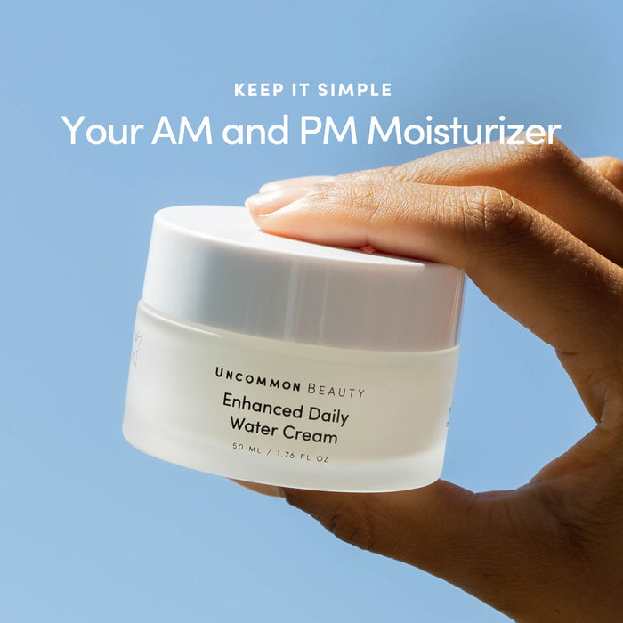 A hand holds a jar of Uncommon Beauty Enhanced Daily Water Cream against a blue background, with text above reading: Keep it simple. Your lightweight moisturizer for a healthy skin barrier, AM and PM.