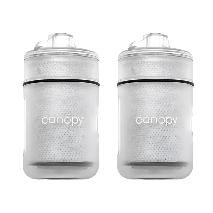 Two clear baby bottles with black accents and 'canopy' branding on a white background