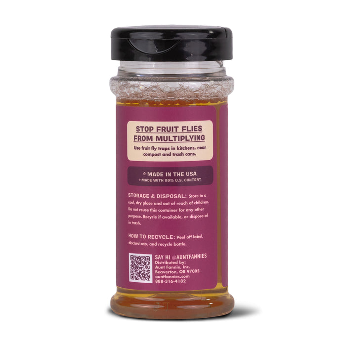 Aunt Fannies FlyPunch! Fruit Fly Trap features a transparent jar with a black lid, containing nontoxic yellow liquid labeled STOP FRUIT FLIES FROM MULTIPLYING. It includes instructions for use, storage, and disposal and is proudly made in the USA for superior pest control.