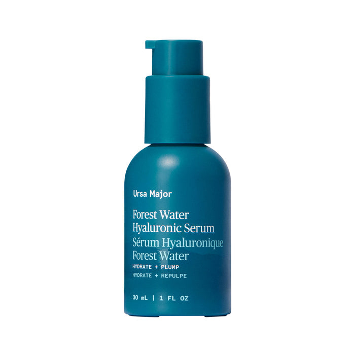 A teal 30 mL (1 fl oz) Ursa Major Forest Water Hyaluronic Serum bottle with a pump dispenser. The English and French label features "Hydrate + Plump" for dehydrated skin.
