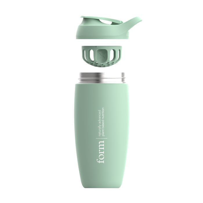 The Form Insulated Shaker Bottle by Form Nutrition, shown in mint green with a print logo and text, is a vacuum-insulated, double-walled design with the lid off to reveal its inner structure. Made from plant-based material, its ideal for maintaining protein shake temperatures.