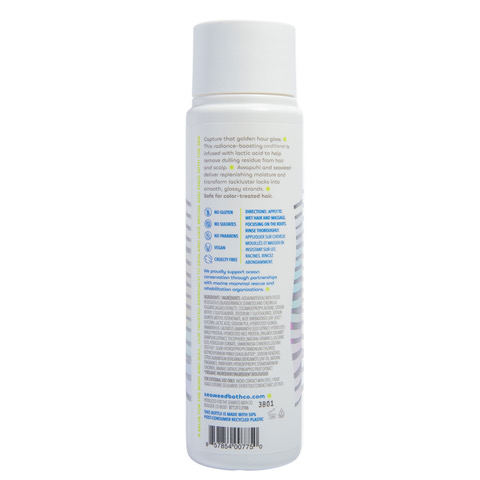 A white cylindrical bottle labeled with VEGAN and NO PARABENS, featuring ingredients like moisture-replenishing elements and usage instructions. The Seaweed Bath Cos Gloss Conditioner has a white cap.