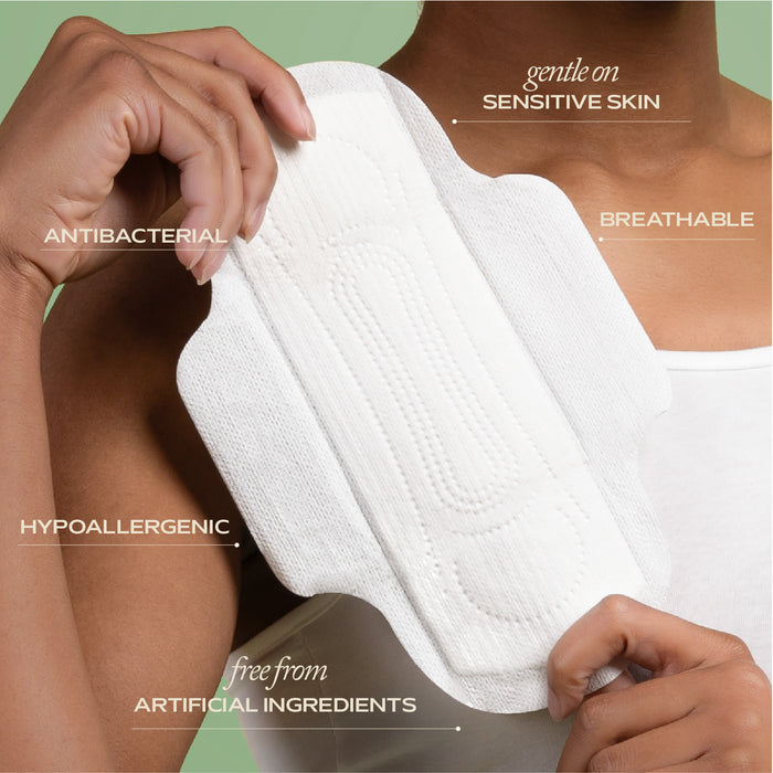 A person in a white tank top holds the Hemp Regular Pad by Hempress Hygienics, featuring organic cotton thats gentle on sensitive skin, breathable, hypoallergenic, antibacterial, and free from artificial ingredients.
