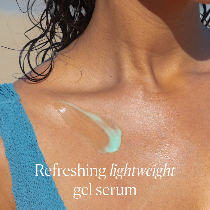 A close-up shows a swipe of OSEA Hyaluronic Body Serum on a person’s shoulder, highlighting the hydrating gel-serum formula. The person wears a blue textured top. The image text reads, “Refreshing lightweight gel serum.”.