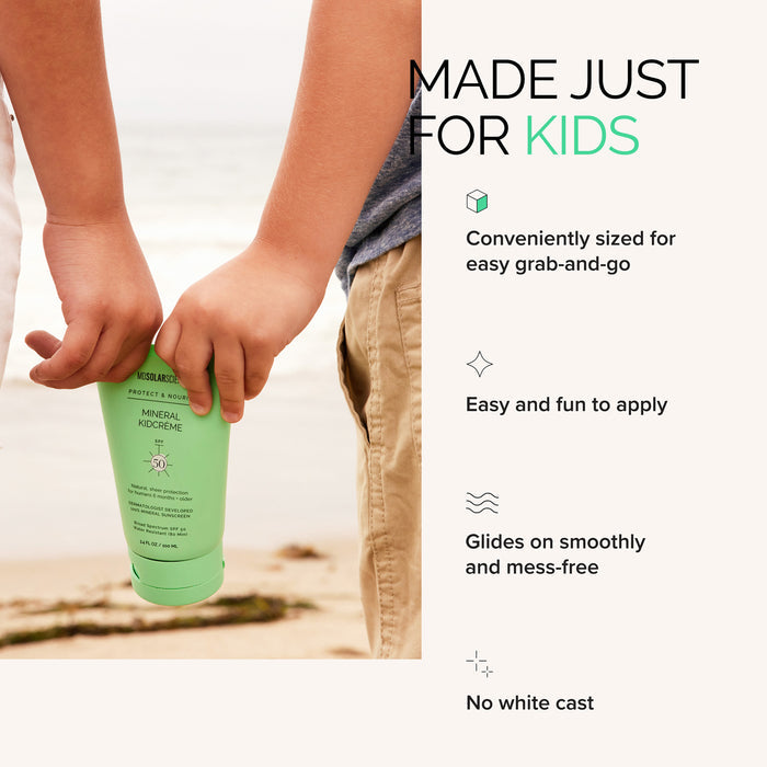 A child holds a green tube of MDSolarSciences KidCreme SPF 50 mineral sunscreen on a sandy beach. Great for kids, this portable size glides on easily, uses non-nano zinc oxide, and leaves no white cast.