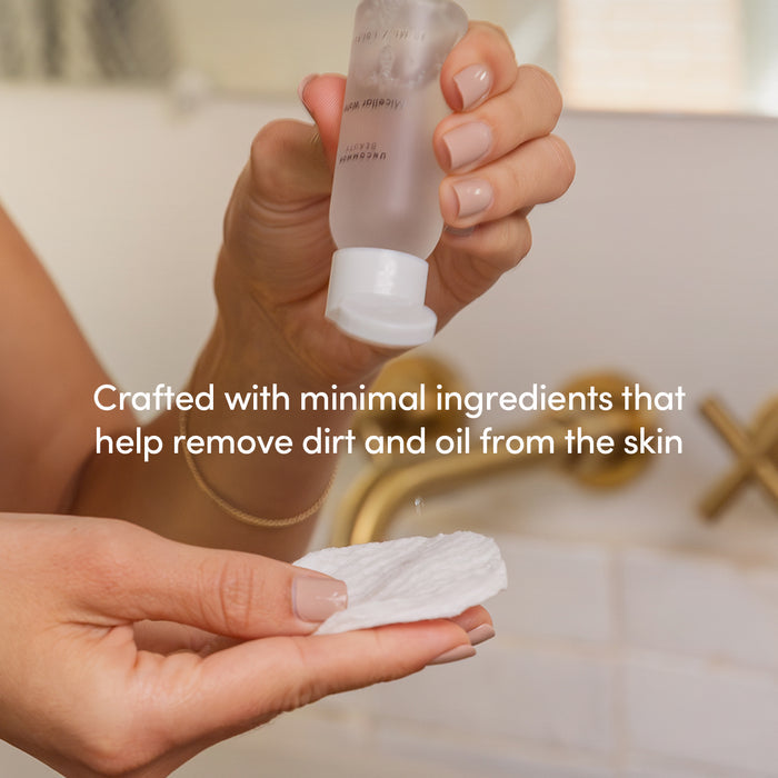 A person pours Uncommon Beauty Mini Micellar Water from a small bottle onto a cotton pad, with text overlay: Made with minimal ingredients to gently remove dirt and oil.