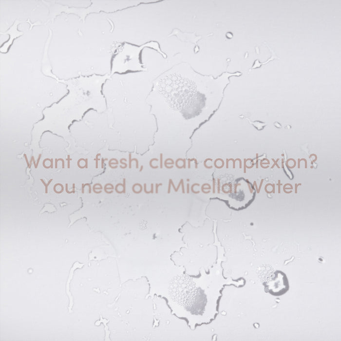 Clear water droplets and bubbles on a white surface with the text: Want a fresh, clean complexion? Try Uncommon Beauty Mini Micellar Water, our gentle cleanser. Light brown font spans the center.