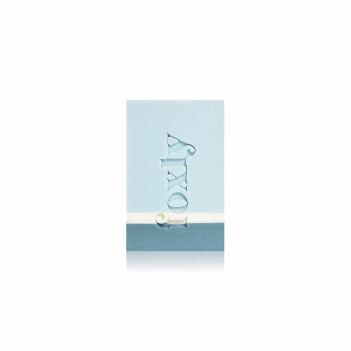 A rectangular light blue Moisturizing Bar Soap by Foxly, with the brand name engraved vertically on the front, made with clean ingredients and nourishing oils, is shown against a white background.