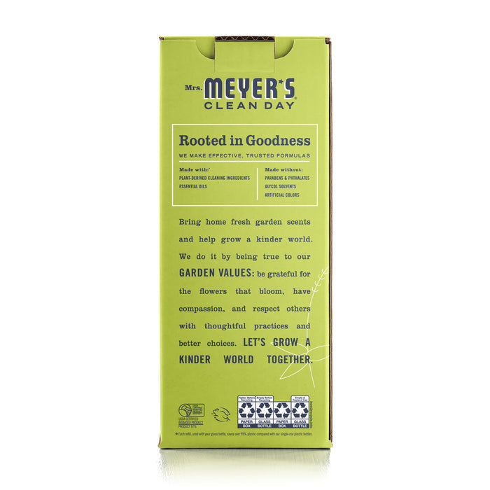 The image shows the back of a green Mrs. Meyers Multi-Surface Concentrate Starter Set package, highlighting its cruelty-free formula with garden-inspired scents. It promotes plant-derived ingredients and essential oils, emphasizing garden values and a mission to grow a kinder world together.