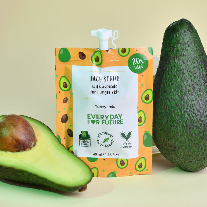 The Nourishing Avocado Face Scrub by Everyday For Future features bright orange packaging with avocado illustrations on a pale green backdrop, including a whole and half avocado. This eco-friendly, cruelty-free product is ideal for natural-ingredient skincare routines.