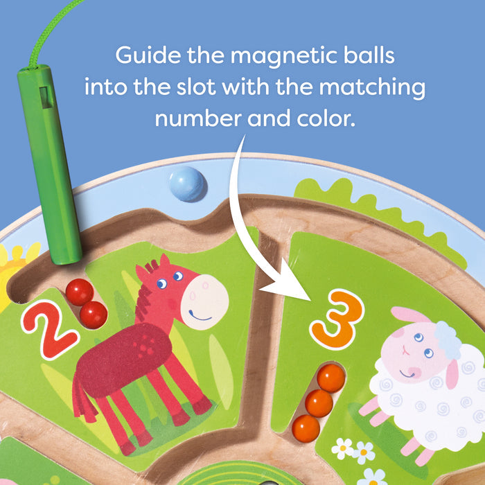 The HABA Number Maze Magnetic Game for ages 2+ features numbered sections with animal illustrations. Red magnetic balls fill section 3 with a sheep, a green wand rests nearby, and simple instructions make it an engaging toddler STEM toy.