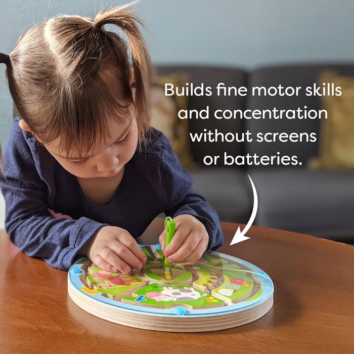 A young girl uses the HABA Number Maze Magnetic Game at a table. Text reads, Builds fine motor skills and concentration—no screens or batteries needed. For ages 2 and up.