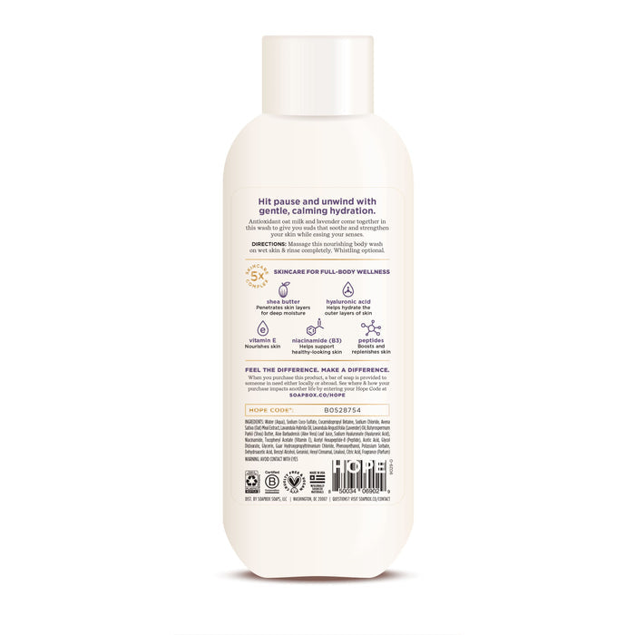 The Oat Milk + Lavender Nourishing Body Wash by Soapbox comes in a white bottle with a beige cap. Its back label displays product benefits, directions, ingredients, and vegan and cruelty-free certifications. Infused with calming lavender for hydration, the design is clean and minimalistic.