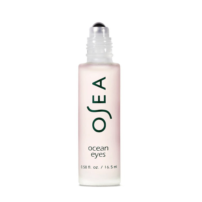 The Ocean Eyes® Age-Defying Eye Serum by OSEA comes in a frosted glass bottle with a roll-on applicator. The label features OSEA vertically and ocean eyes horizontally in dark green. This 0.58 fl. oz. (16.5 ml) serum targets dark circles and puffiness around the eyes.