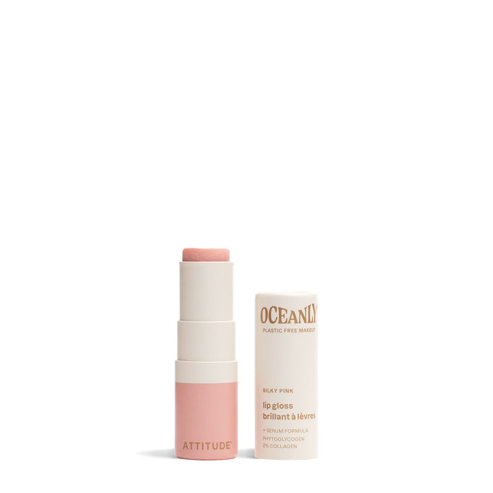 A tube of ATTITUDE Oceanly Lip Gloss in Silky Pink stands with its removed cap, showing the pink balm. Both the tube and cap feature cream and pastel pink colors. Made with vegan, cruelty-free, naturally sourced ingredients.
