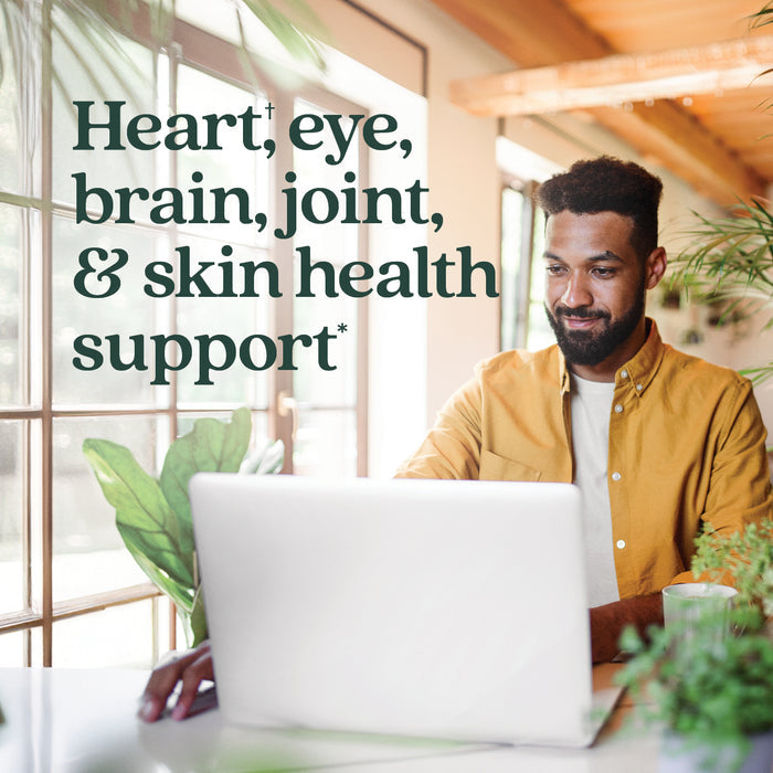 A man sits at a desk with a laptop, surrounded by plants and natural light, next to text that reads: New Chapter Omega-3 Complex—supports heart, eye, brain, joint & skin health* with heart-healthy Omega-3s.