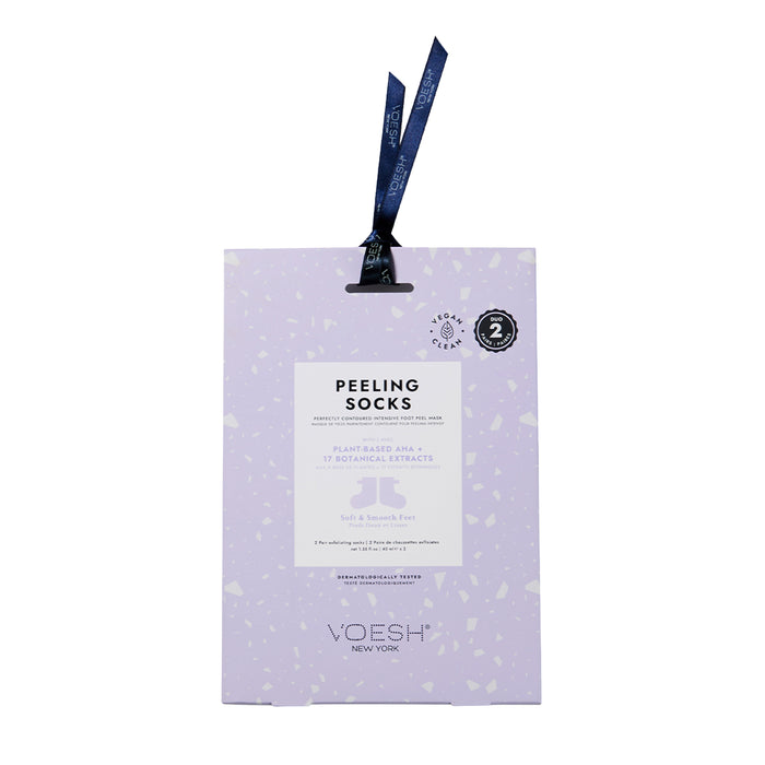 A rectangular purple package of VOESH New Yorks Peeling Socks Duo contains vegan ingredients and features plant-based AHA and 17 botanical extracts for exfoliation. A dark blue ribbon adorns the top, adding elegance.