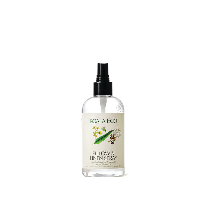 A clear spray bottle labeled "Koala Eco Pillow & Linen Spray" with a black nozzle, featuring botanical illustrations and green accents, is set against a white background—an elegant eucalyptus pillow spray from Koala Eco.