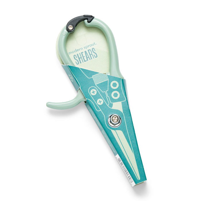 Modern Sprouts Pruning Shears come in turquoise packaging and feature a sleek, modern design with a slightly open handle for an elegant touch. The minimalist packaging includes an illustration of pruning shears labeled modern sprout SHEARS.