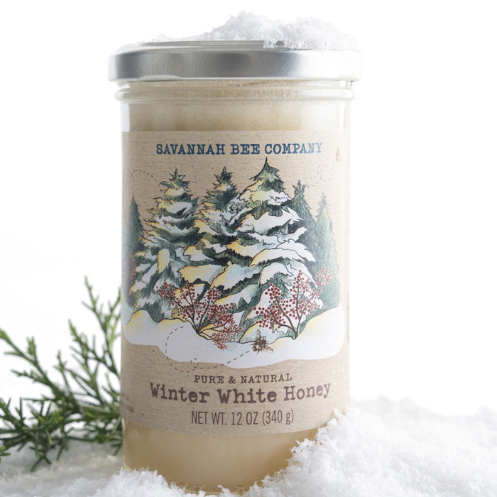 The Savannah Bee Company Pumpkin & Winter White Whipped Duo sits in snow, its seasonal labels evoking crisp days—perfect for pairing your favorite fall flavors with Pumpkin Spice or enjoying the sweet taste of Winter White honey.