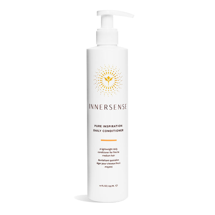 A white bottle of Innersense Organic Beauty Pure Inspiration Daily Conditioner with a pump, showing a yellow abstract flower design. This lightweight, moisturizing, detangling conditioner holds 10 fl oz (295 mL) as stated on the label.