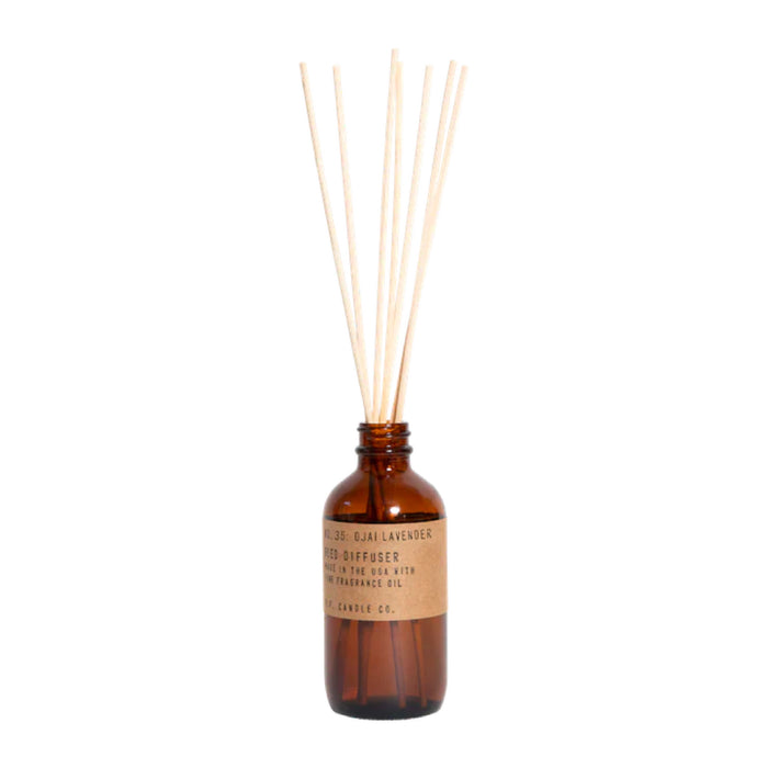 The Reed Diffuser by P.F. Candle Co. features a brown glass bottle and wooden reeds, labeled No. 25 Sula Lavender & Teakwood, combining floral notes with rich teakwood essence for fragrance distribution.