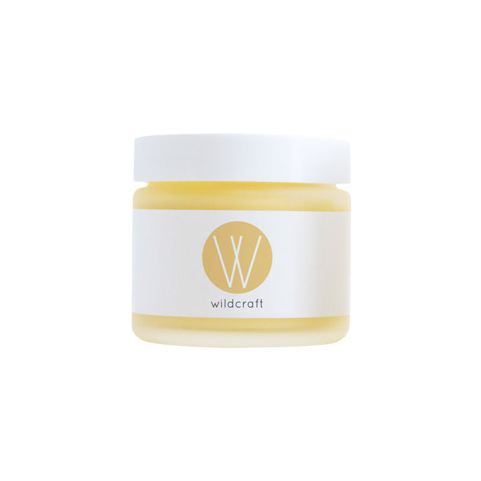 A petite glass jar with a white lid contains a creamy substance marked by a simple gold W. Its labeled Wildcraft, suggesting its the Restore Face Cream—a handcrafted skincare indulgence for dry skin.