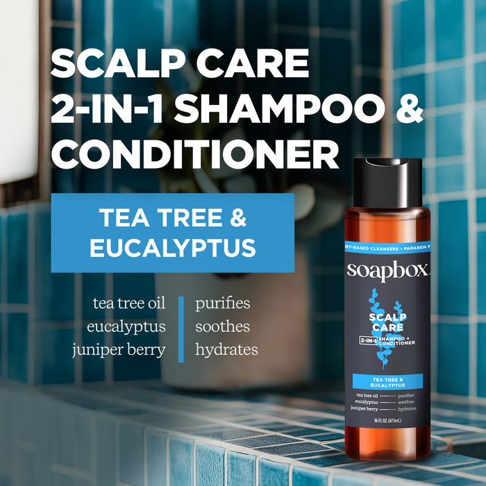 A bottle of Soapbox Scalp Care 2-in-1 rests on a tiled bathroom surface, promoting purifying, soothing, and hydrating effects. Its sulfate-free for fuller, stronger-looking hair. The blue tiles provide a clean backdrop.