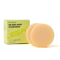 A box labeled Leaf Shave Shave Soap sits beside two round, beige bars. The natural soap creates a creamy lather and comes in a light green box marked Fragrance Free with 2 Bars Net Wt 3 OZ on the front.