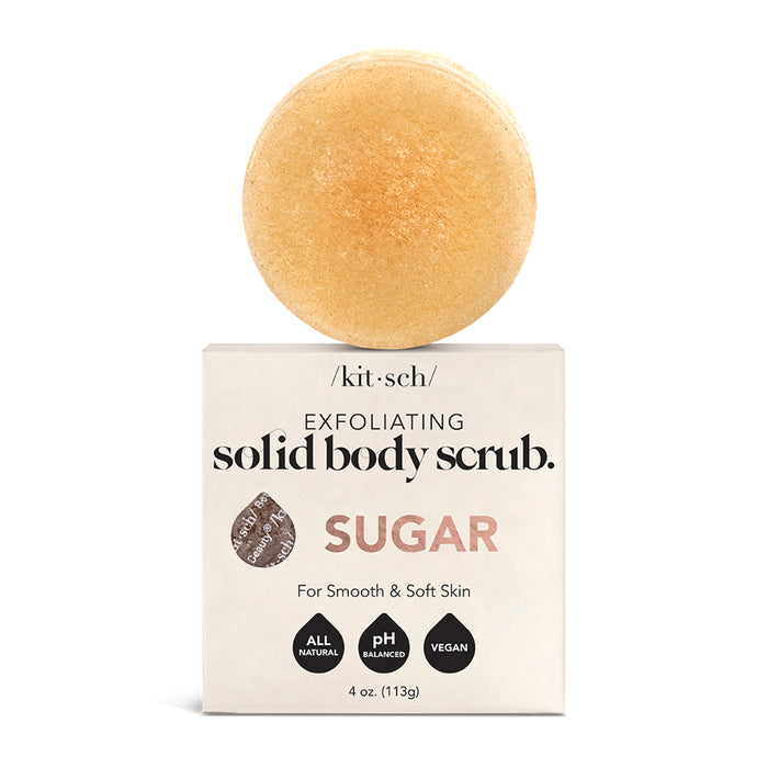 The Kitsch Sugar Exfoliating Solid Body Scrub is a round, beige bar with vanilla bean atop a white box. It’s all-natural, pH balanced, and vegan. Weighing 4 oz (113g), its designed to leave skin smooth and soft.