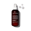 A brown bottle of Terra Beauty Bars Super Boost+ Styling Mist with a white spray nozzle stands proudly, its label highlighting salon-quality hair care. Three droplets rest beside it on a white background, casting a shadow to the right.