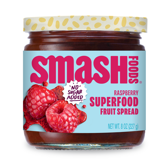 A jar of Smash Foods Superfood Jam - Raspberry with chia seeds, featuring raspberries on the label, red and blue text, a “No Sugar Added!” badge, and containing 8 oz (227 g) of delicious fruit spread.