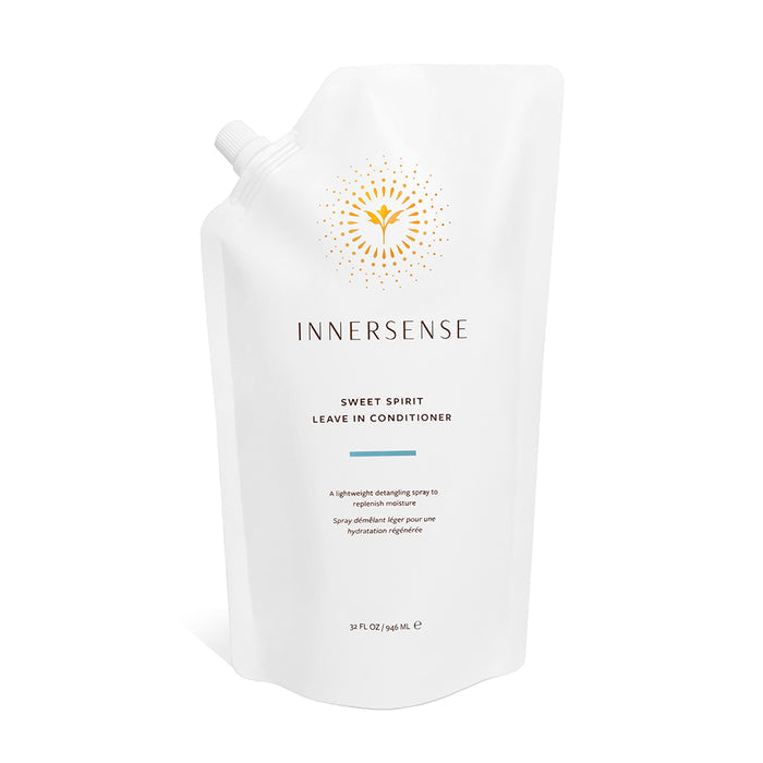 A white refill pouch of Innersense Organic Beauty Sweet Spirit Leave In Conditioner, featuring a gold sunburst logo and minimalist text, delivers nourishing care with certified organic plant extracts and emollient oils.