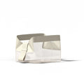 The Parcel by Cadence is a transparent rectangular TSA-approved travel bag with wide off-white handles, an adjustable strap, and a magnetic travel system—shown against a plain white background.
